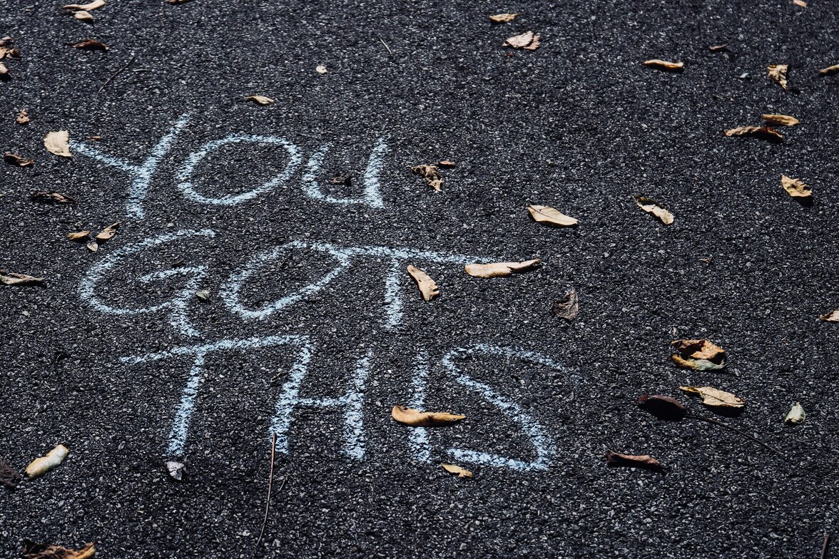 "you got this" written in chalk on black asphalt